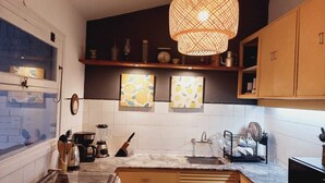 A kitchen with a gas stove, a sink, and a hanging light fixture. - Tile villa in residential neighborhood, 3 minutes from the beach. (Punta del Este)