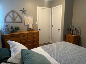 Ein Schlafzimmer mit Bett, Schminktisch, Nachttisch und Wanddekoration.