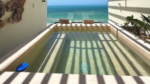 A balcony with a view of the ocean, a hot tub, and wooden slats overhead. - Waterfront penthouse in Yucalpetén Resort Marina (Progreso)
