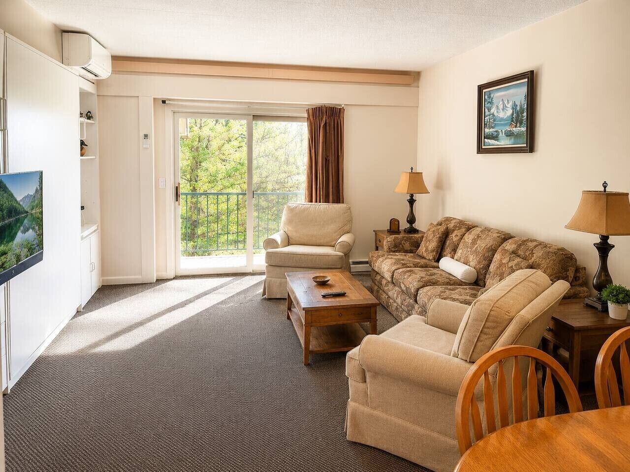 Une pièce comprenant un canapé, un fauteuil, une table basse et un téléviseur.