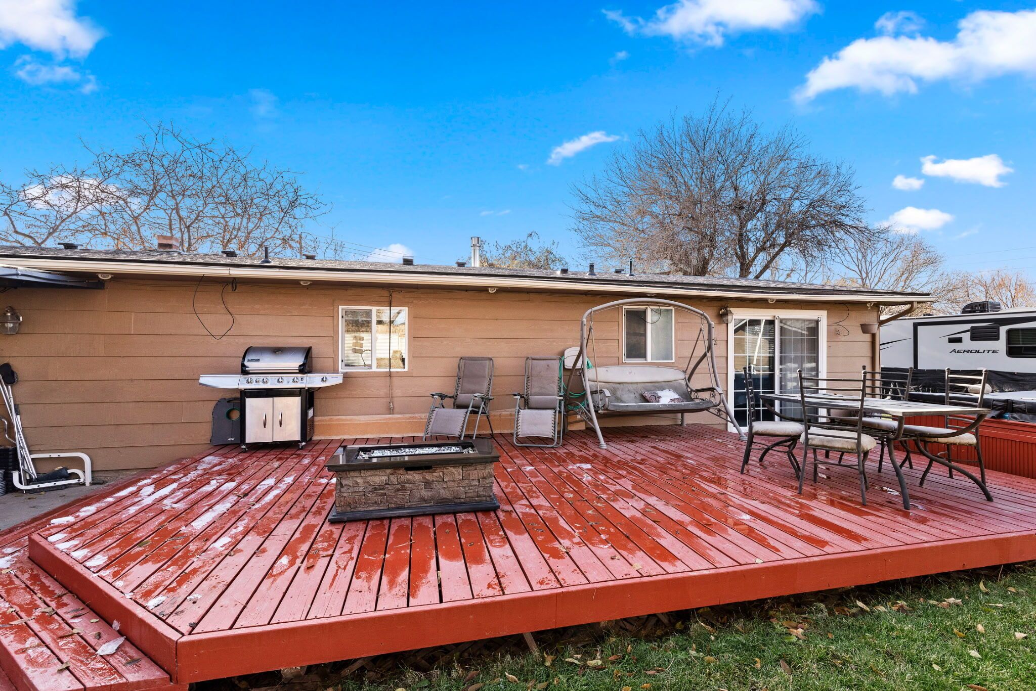 Une terrasse couverte équipée d’un barbecue, de sièges et d’un jacuzzi.