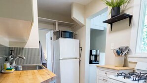 Une cuisine compacte équipée d’un four à micro-ondes, d’un réfrigérateur, d’une cuisinière et d’un évier.