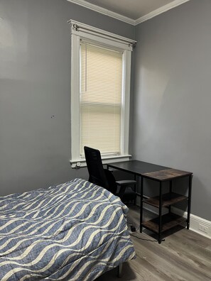 Ein Schlafzimmer mit einem Bett, einem Schreibtisch und einem Stuhl.