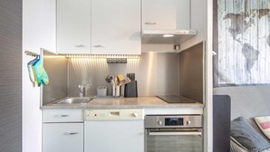 A modern kitchen with stainless steel appliances, a double sink, and a built-in oven. - Quiet Mountain Stay in Chamrousse (Chamrousse)