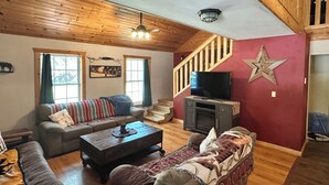 A cozy living room with a wooden ceiling, a staircase, a television, and a star decoration on the wall. - RiverBend Retreat
Cozy 1 bedroom, 2 loft cabin. (Leakey)