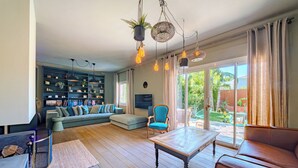 A living room with a sofa, armchair, coffee table, and bookshelf. - 12345677890 (Montpellier)