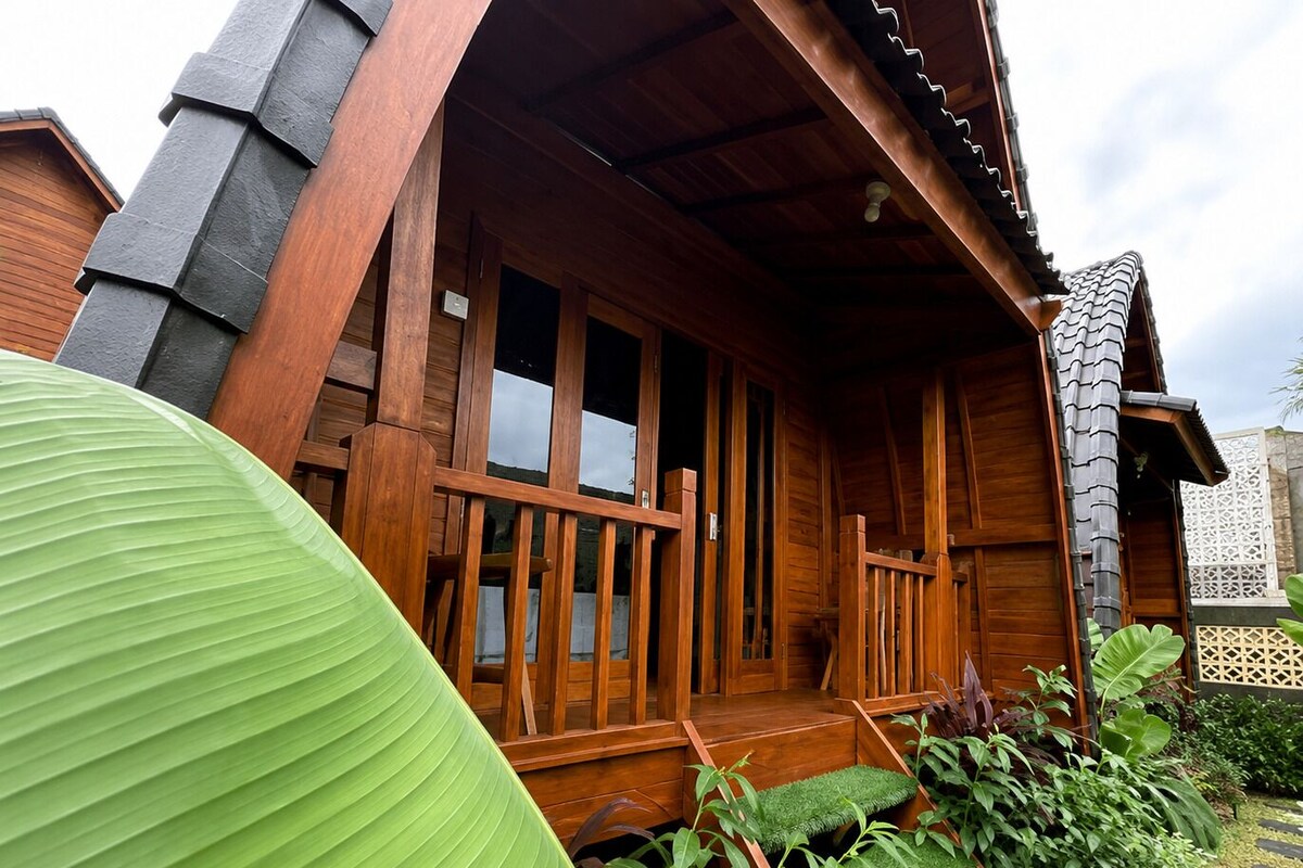 Ein Holzhaus mit Veranda, Treppe und Garten.
