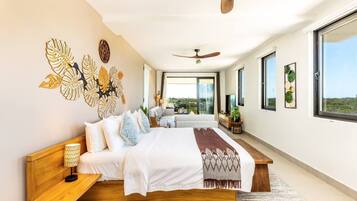 Un dormitorio moderno con una cama grande, un ventilador de techo y vistas al exterior.