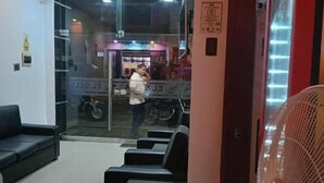 Una zona de recepción con pared de vidrio, un ventilador y un área de descanso.