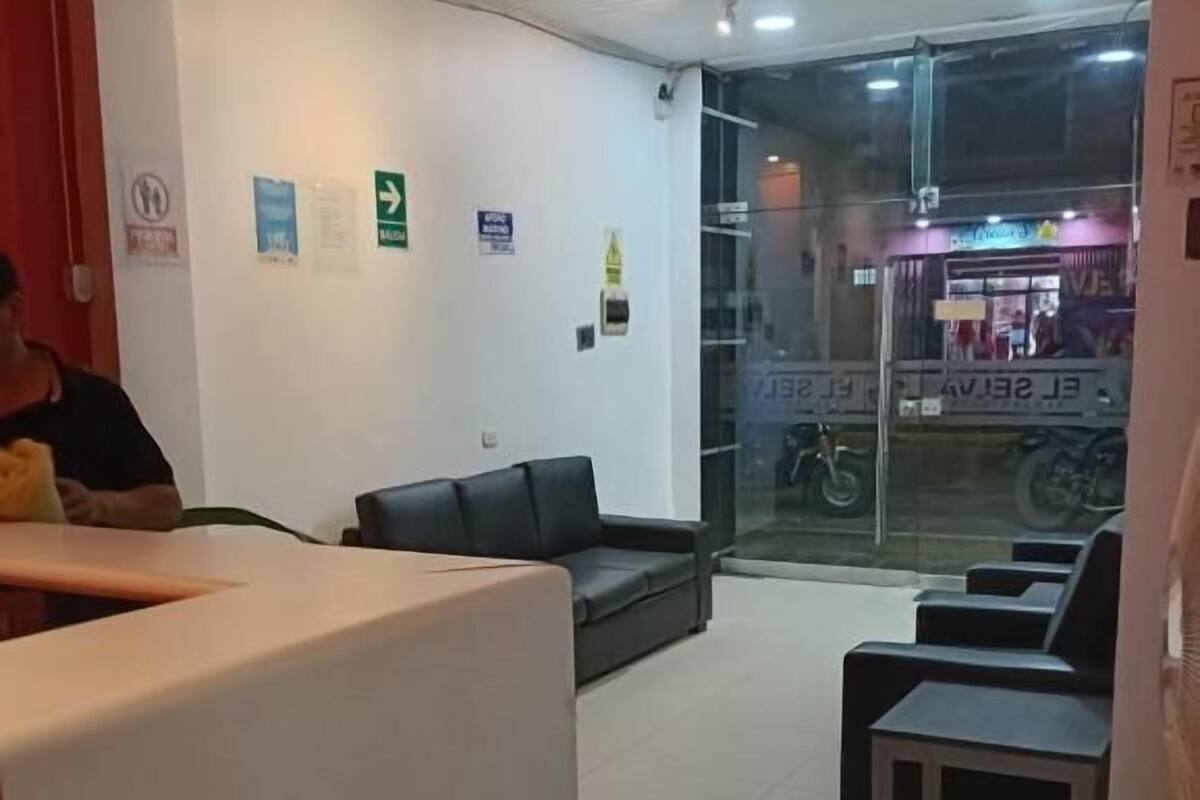A reception area with a counter, seating, and a glass door leading outside.