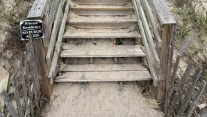Una escalera de madera que conduce a una residencia privada, con señalización que indica que no hay acceso público.