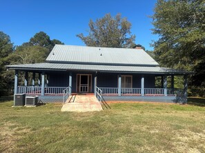 A two-story house with a porch, a front door, and a small front yard.