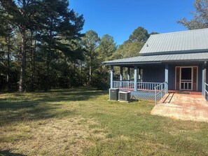 A building with a porch, a covered area, and a door. - The Lakehouse at Antioch on West Point Lake (LaGrange)