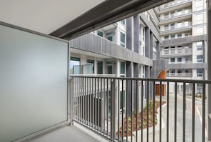 Ein mehrstöckiges Gebäude mit Balkonen, einem Metallgeländer und Blick auf die Straße.