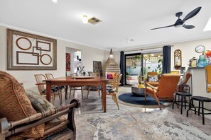 A spacious living area with a dining table, chairs, a sofa, and a ceiling fan. - The Sellicks Atelier Beachside Vintage Retreat (Sellicks Beach)