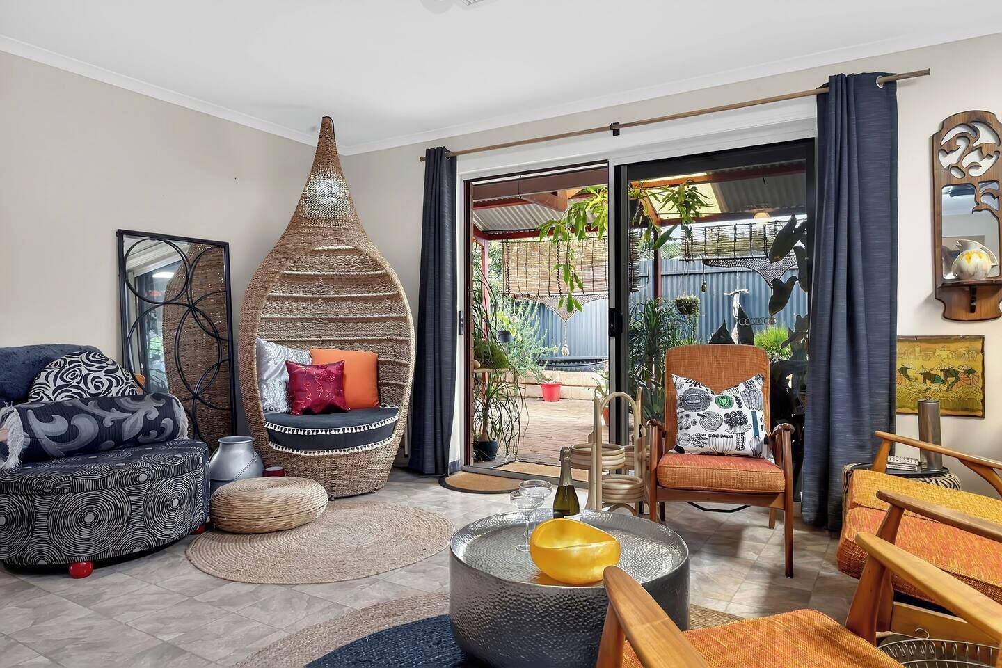 Have long conversations over a glass of McLaren Vale wine in the eclectic second living area beside the kitchen, where collected objects, bold artworks, and rich textures give the space a warm artistic energy.