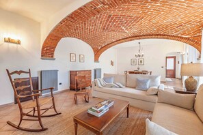 A living room with a brick ceiling, a sofa, a rocking chair, and a coffee table.
