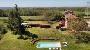 Una propiedad residencial con piscina, un pabellón y vistas al campo.