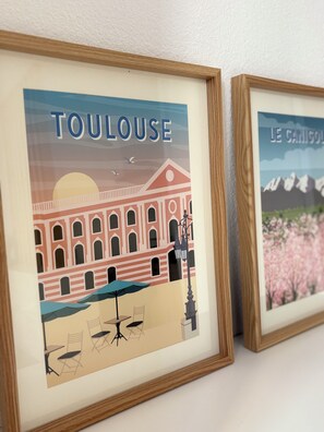 Zwei gerahmte Kunstwerke, die Gebäude zeigen. Auf den Bildern sind die Worte 'TOULOUSE' und 'LE CANIGOU' zu sehen.