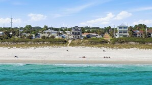 A beachfront property with a sandy beach, ocean view, and multiple buildings. - NEW Laguna Serenity | 7BR Gulf Front | Pool | LSV/Bikes (Panama City Beach)