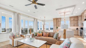 A spacious living area with a sofa, coffee table, and a view of the sky. - NEW Laguna Serenity | 7BR Gulf Front | Pool | LSV/Bikes (Panama City Beach)