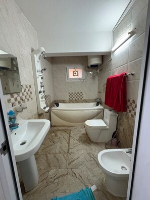 Ein Badezimmer mit einer Badewanne, einer Toilette und einem Waschbecken.