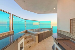 Ein modernes Badezimmer mit einer großen Badewanne, einer gläsernen Dusche und Blick auf den Ozean.