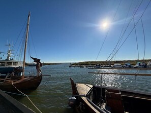 Ein Yachthafen mit vertäuten Booten, ruhigem Wasser und blauem Himmel.