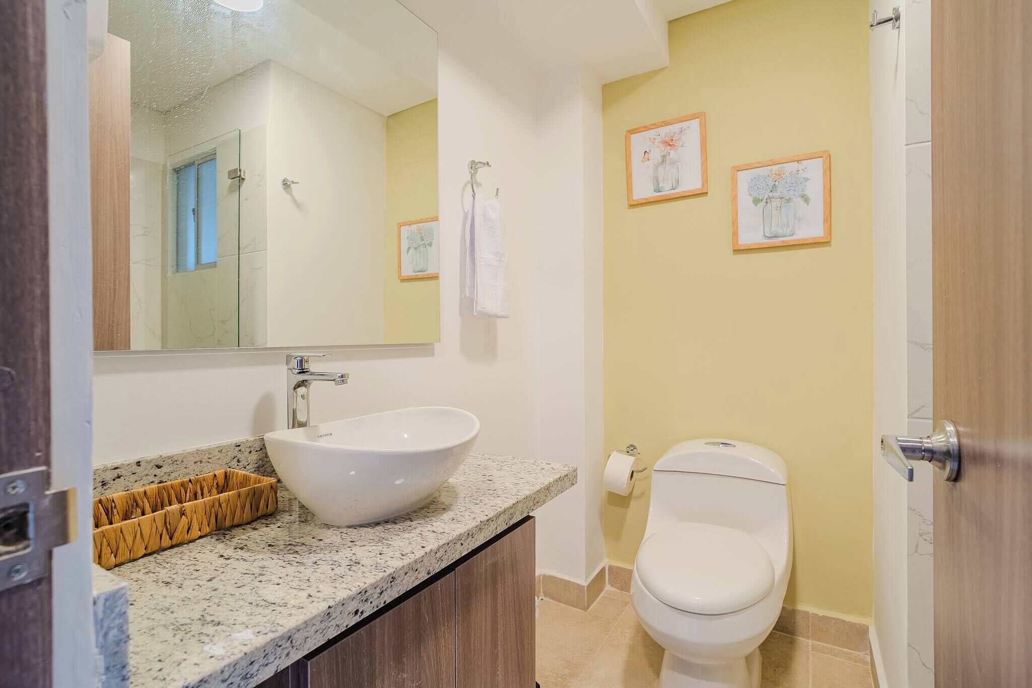 A bathroom with a white sink, a toilet, and a mirror.