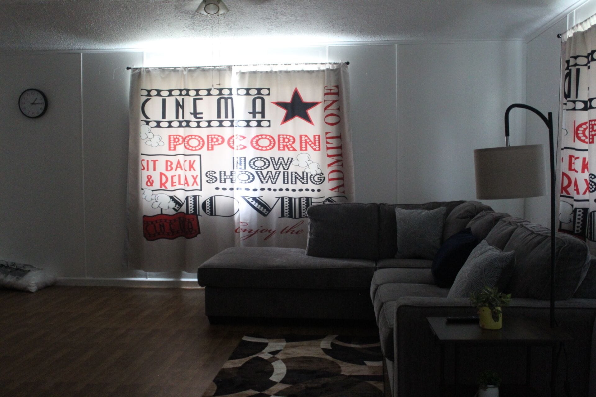 Un salon avec un canapé, une lampe et un tapis à motifs.