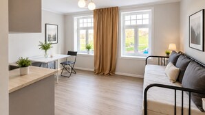 Un salon moderne comprenant un canapé, une table à manger et un coin cuisine.