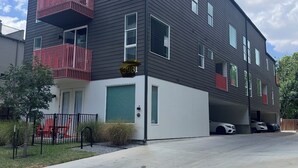 A modern multi-story building with a garage parking area. - Dallas Downtown, FIFA Close to All the FUN! (Dallas)