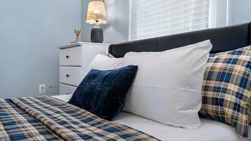 A bed with a plaid bedspread, white pillows, and a dark headboard.