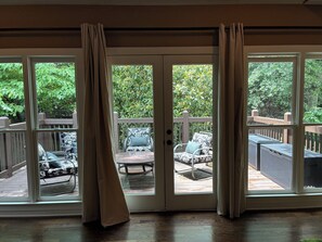 Ein Zimmer mit einer Schiebetür und einem Glasbereich, der auf eine Terrasse mit Gartenmöbeln führt.
