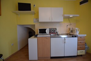 A compact kitchen with a microwave, stove, and coffee maker. - Studio Apartment With Terrace and sea View (Opatija)