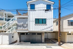 Ein mehrstöckiges Wohngebäude mit Garage, Balkon und Treppe.