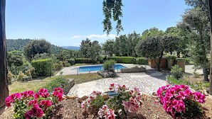 Un espace piscine offrant une vue dégagée sur le paysage environnant, notamment sur les arbres et une chaîne de montagnes lointaine.