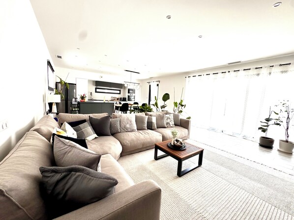 A modern living room with a sofa, coffee table, and potted plants. - 4-bedroom villa with a pool that isn't visible from the outside (Pomérols)