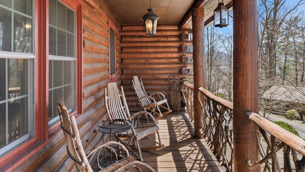 A log cabin with a porch, rocking chairs, and a hanging lantern. - Welcome to your peaceful 4 Br cabin, minutes from the historic Lake Junaluska. (Waynesville)