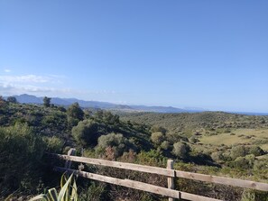 Ein malerischer Blick auf eine hügelige Landschaft mit einem Holzzaun im Vordergrund.