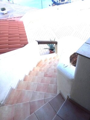 A staircase leading to a rooftop area with a potted plant and a railing. - Fpo-cinz01 in Ottiolu (Budoni)