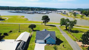 A residential area with a house, a road, and a large body of water with docks. - Lake Access-Boat Parking- 2 King Beds-Sleeps 10 (Eufaula)