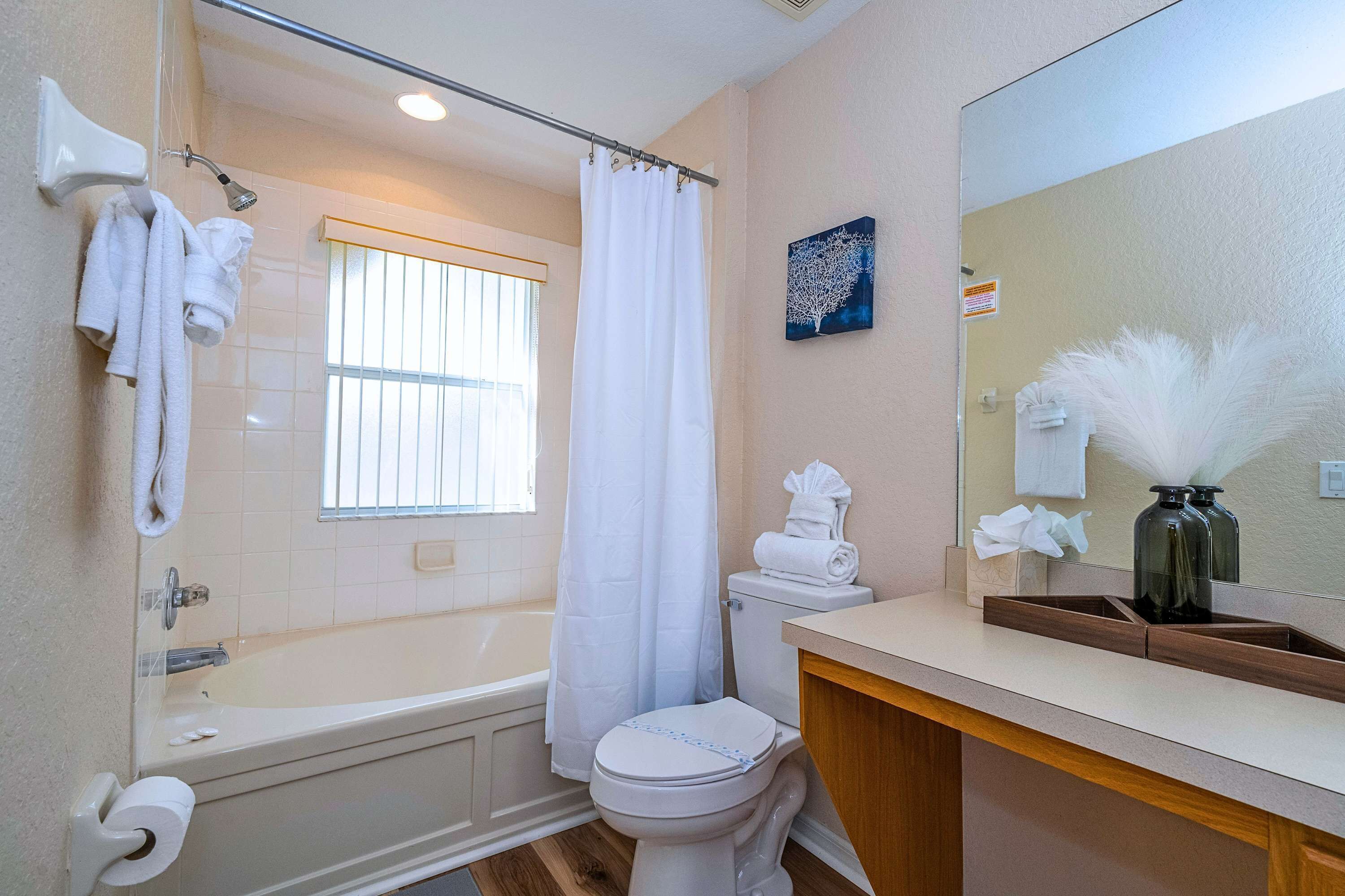 Et badeværelse med badekar, toilet og håndvask.
