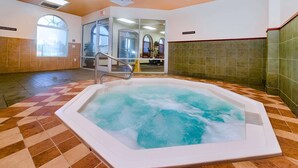 A hot tub in a room with a checkered floor, a glass door leading to another room, and a tiled wall. - Spacious Townhome Near Disney, Free Parking (Davenport)
