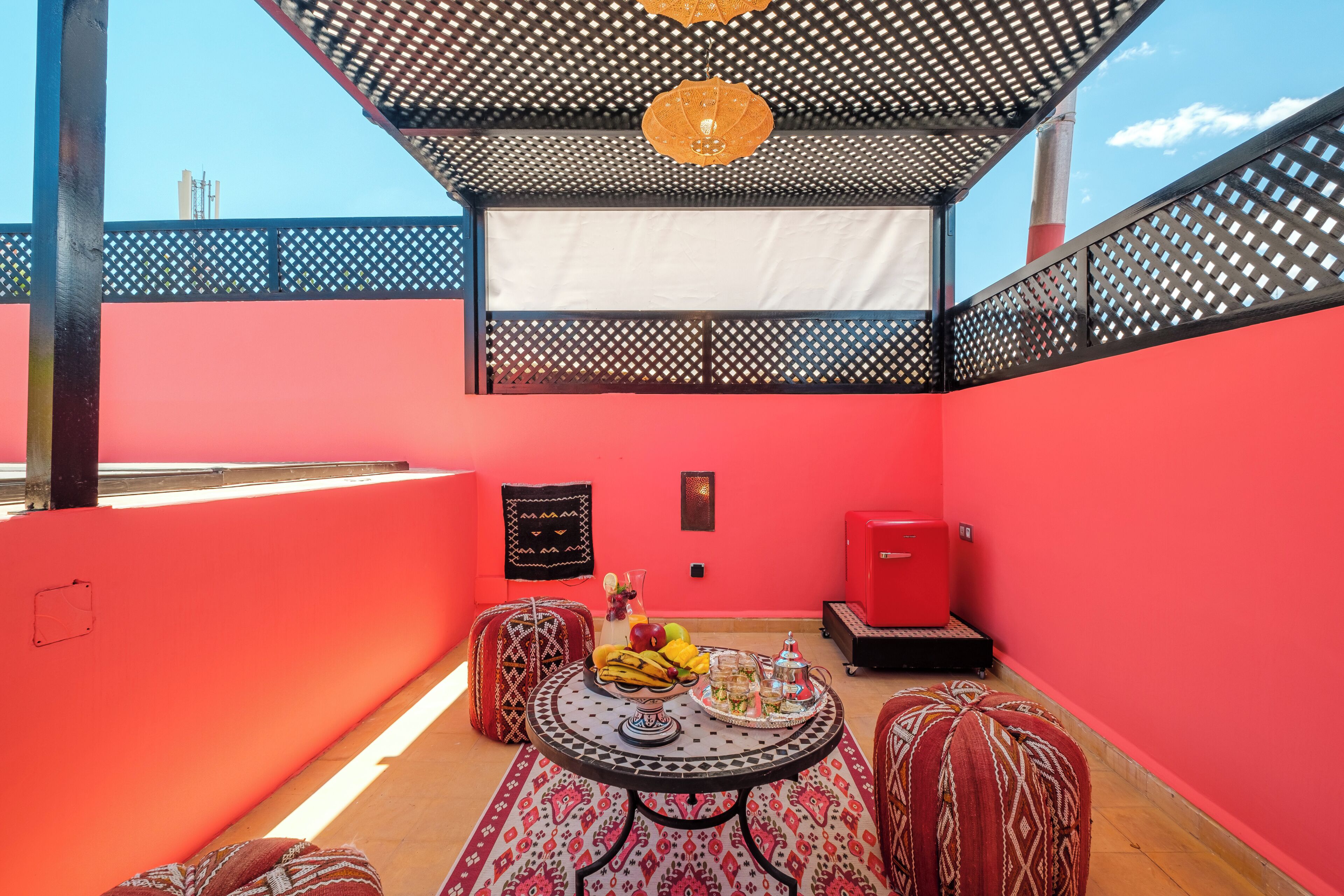 Ein Zimmer mit roter Wand, einem gemusterten Tisch und einem roten Schrank.