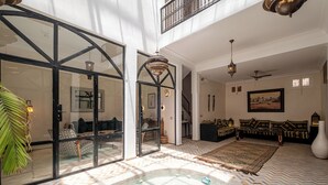 A spacious interior with a large open area, a pool, and a seating area with patterned cushions. - Expérience Riad privé Médina Jacuzzi (Marrakech)