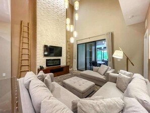 Ein modernes Wohnzimmer mit Flachbildfernseher, einer Sofagarnitur, einem Couchtisch und einer Ziegelwand.