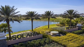 Ein Resort mit dem Schild 'SOLARA', Palmen, einem Gewässer und gepflegten Rasenflächen.