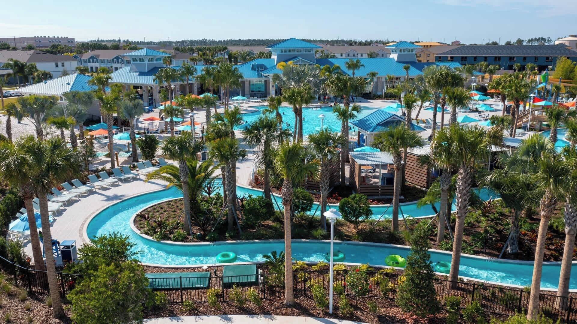 A resort with multiple swimming pools, palm trees, and beach chairs.