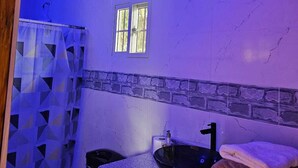 A bathroom with a bathtub, a sink, a window, and towels. - Tocumen Comfort Stay (24 de Diciembre)